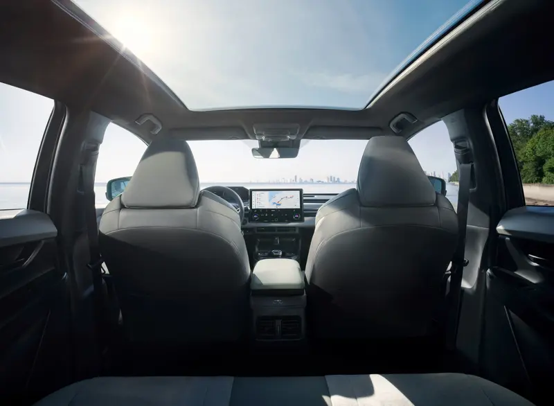 Achterbank van de Toyota C-HR+ met zicht op het panoramadak en de voorstoelen