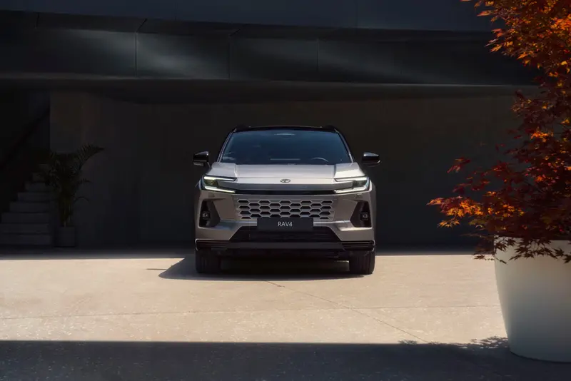 Vooraanzicht van de Toyota RAV4 voor een modern gebouw